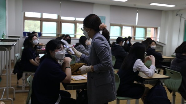 코로나19로 80일만에 등교한 춘천여고 3학년 1반 담임교사가 간격을 유지한 채 앉아있는 학생들의 발열 상태를 체크하고 있다. (사진=윤왕근 기자)