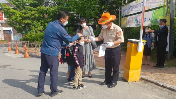 27일 초등학교 1,2학년 등교개학이 이뤄진 가운데 춘천 호반초교 교사가 한 학생의 체온을 검사하고 있다. (사진=윤왕근) 