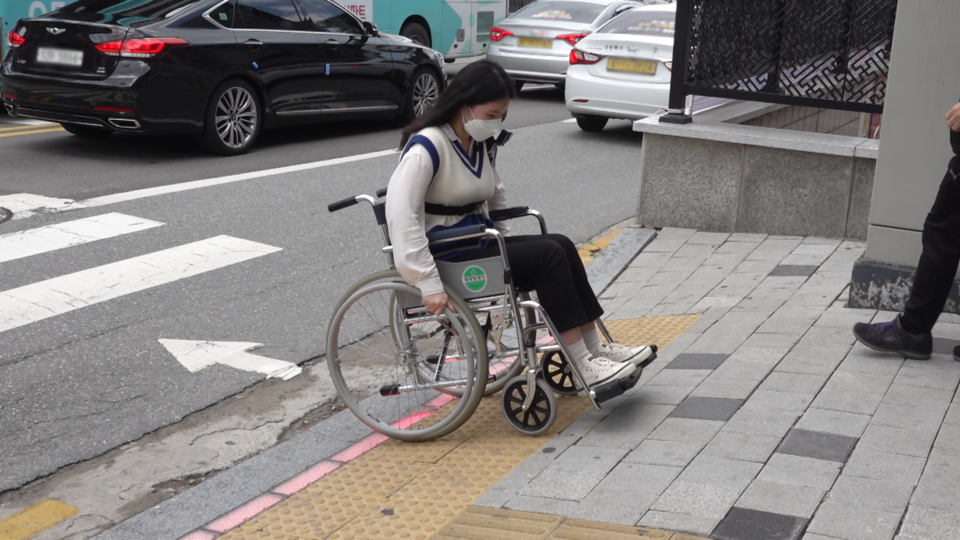 보도 진입로 경사가 높아 아무리 힘을 줘도 휠체어가 움직이지 않았다. 차로로 흘러내리지 않기 위해 안간힘을 쓰는 모습. (사진=박지영 기자)