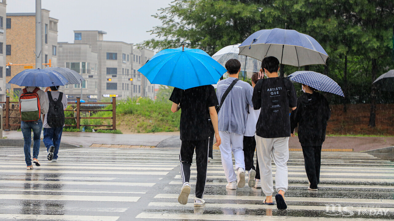 전국적으로 장마가 시작된 23일 춘천시 동면 일대에서 시민들이 우산을 쓰고 걸음을 재촉하고 있다.