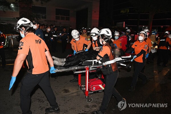 22일 오후 경기 부천 모 호텔의 화재 현장에서 소방대원들이 환자를 이송하고 있다. 이 불로 7명이 숨졌고 다른 투숙객 등 12명이 다쳤다. [부천시 제공]