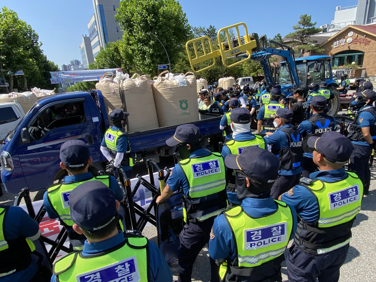 4일 농민들이 트럭에 싣고 온 벼 가마를 강원도청 앞에 쌓아두려고 시도하면서 경찰과 실랑이가 벌어지고 있다. (사진=연합뉴스)